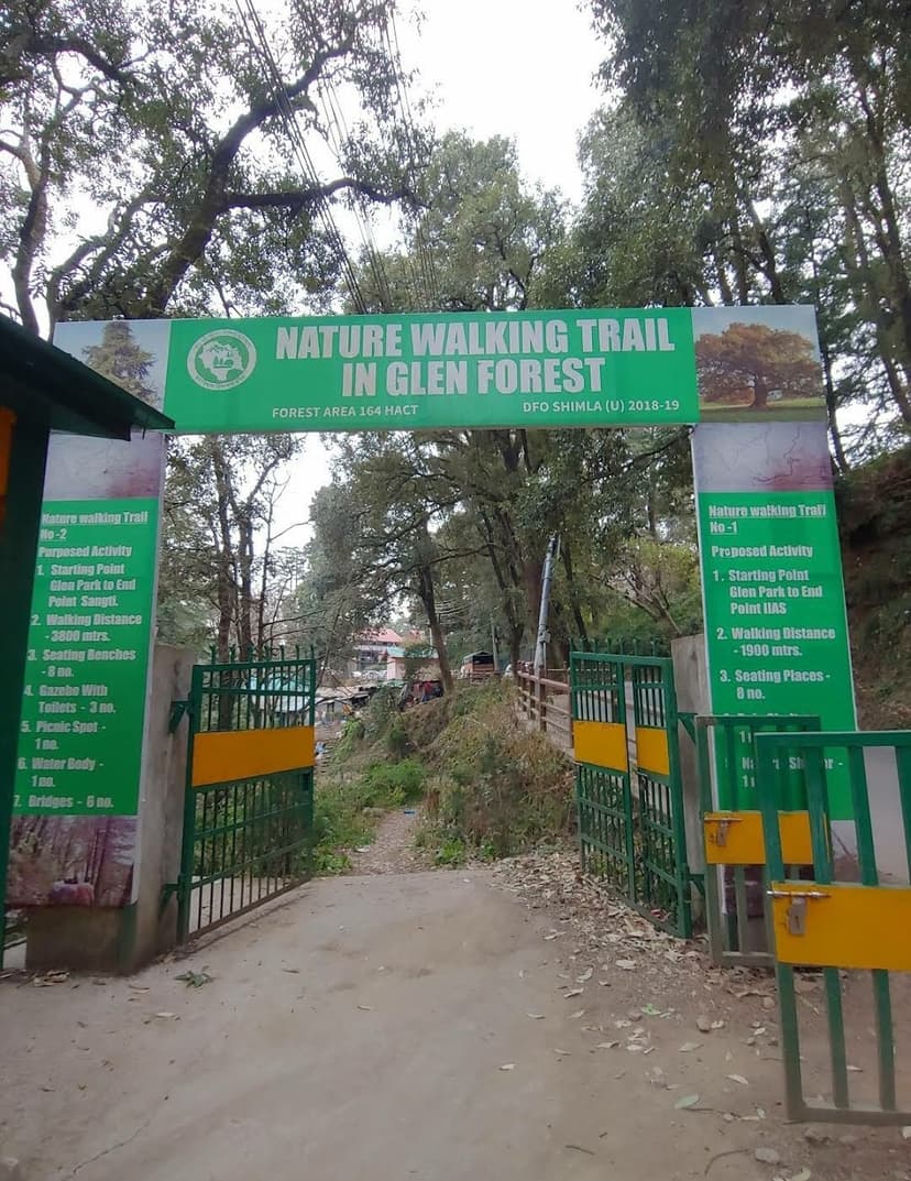 Green entrance gate reading Nature Walking Trail in Glen Forest with a forest path leading into dense trees in Shimla