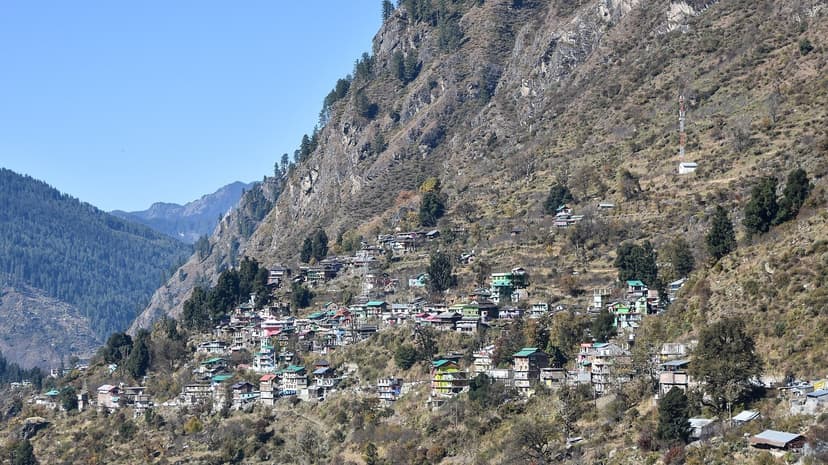 Cluster of colourful tin-roof houses on a steep Parvati hillside near Barshaini