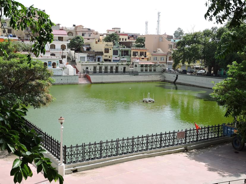 Rani Tal pond in Nahan with green water, ornamental iron railing in front and the old town houses rising behind