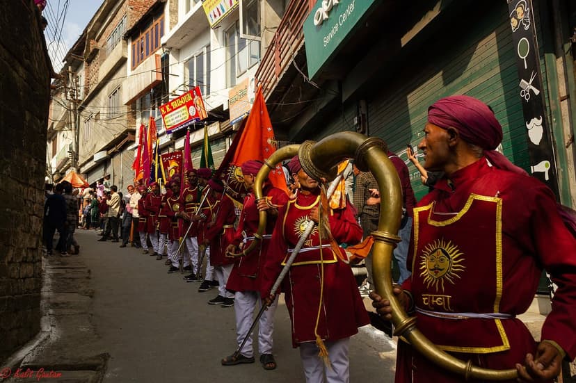 Brass band in red uniforms marching through Chamba streets during the Minjar Fair procession