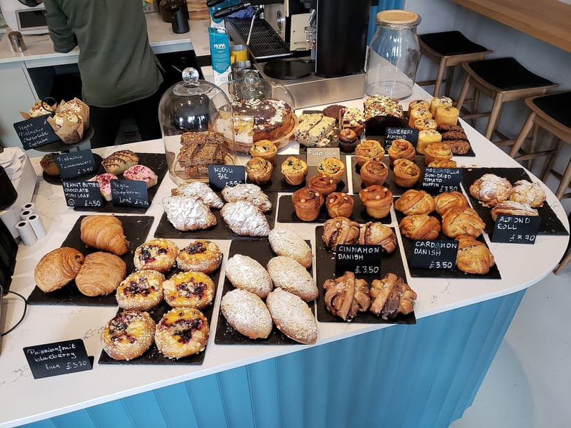 A bakery counter with croissants, Danishes and cinnamon rolls with handwritten price tags