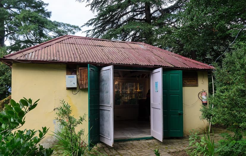 Nicholas Roerich Art Gallery and Museum building in Naggar with green doors open, surrounded by deodar trees and garden