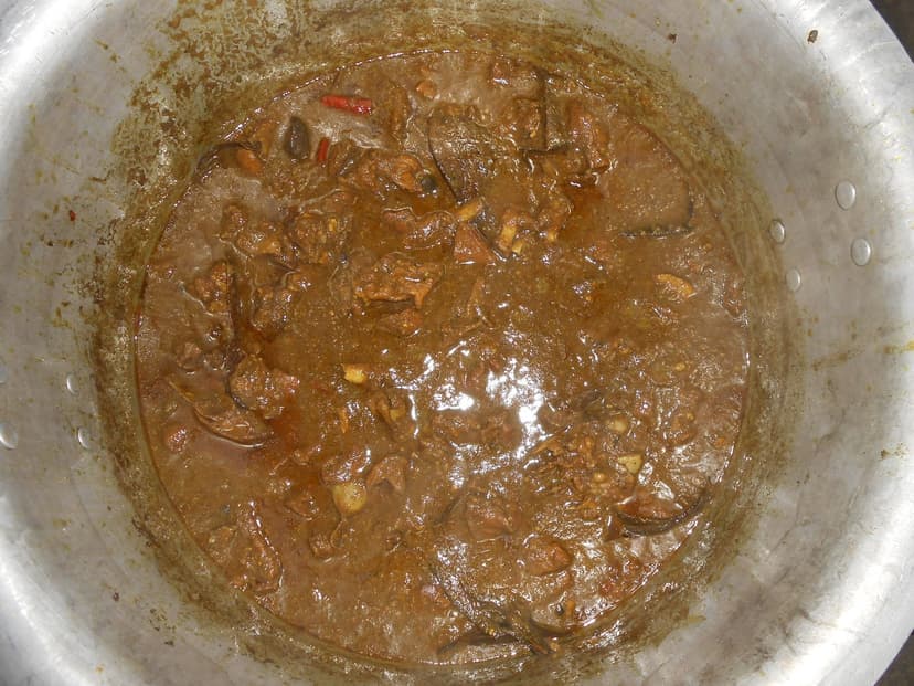 Indian-style slow-cooked mutton curry in a steel pot, brown gravy with bone-in pieces, the kind of everyday non-veg cooking the HP government officially calls the norm